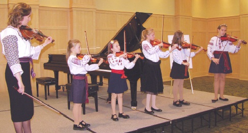 1 - Oksana Konopada (left) leads pupils in violin ensemble playing Leontovych’s Shchedryk – recipients of special award in memory of Dr. Petro Pidkowich