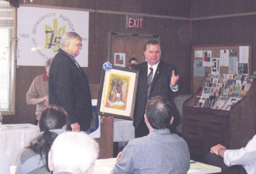 Тарас Підзамецький, колишній президент УНО Канади, передає картину-подарунок голові Центральної Управи ОДВУ Олександрові Процюку з нагоди 80-ліття УНО Канади
