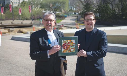 3 - Outgoing President Danylo Korbabicz presents the Hon. Gene Zwozdesky with a token of appreciation, a painting by Ukrainian Canadian Artist Iryna Karpenko