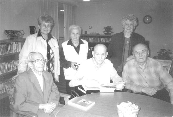 В центрі з книгою в руці сидить Петро Амвросійович Данелюк, перший зліва – сидить Дмитро Назарович Яремчук