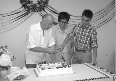 L. to R. Ihor Ostash, his wife Maryna Hrymych and their son Danylo cutting celebratory “Farewell Cake”.