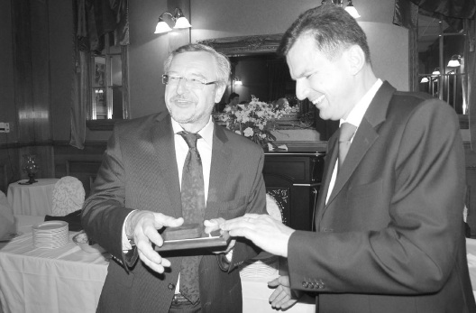 Андрій Левкович (справа) вручає срібну монету Зенону Потічному