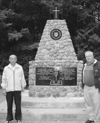Зліва направо: В. Олійник та П. Ковальчик.  Оселя “Сокіл”, Гакстон, Онтаріо. Біля пам’ятника жертвам Голодомору 1932-1933 рр. в Україні